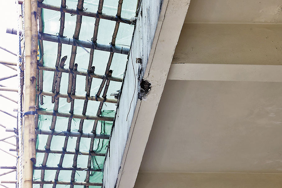 ◆旺角新興大廈簷篷石屎批盪剝落墜落下方巴士站，幸未有擊中途人。 香港文匯報記者劉友光  攝