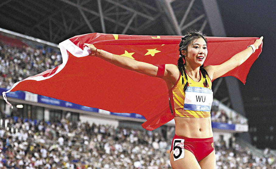 ◆ 吳艷妮身披國旗繞場慶祝。 新華社