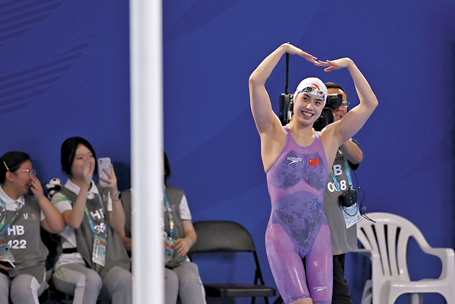 ◆ 在今次大運會獨取9金的張雨霏賽後向觀眾「比心」。 中新社