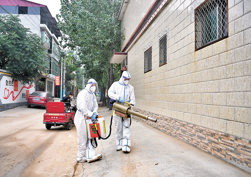 ◆8月6日，在河北省涿州市刁窩鎮白塔村，志願者在民房前進行消殺作業。 新華社