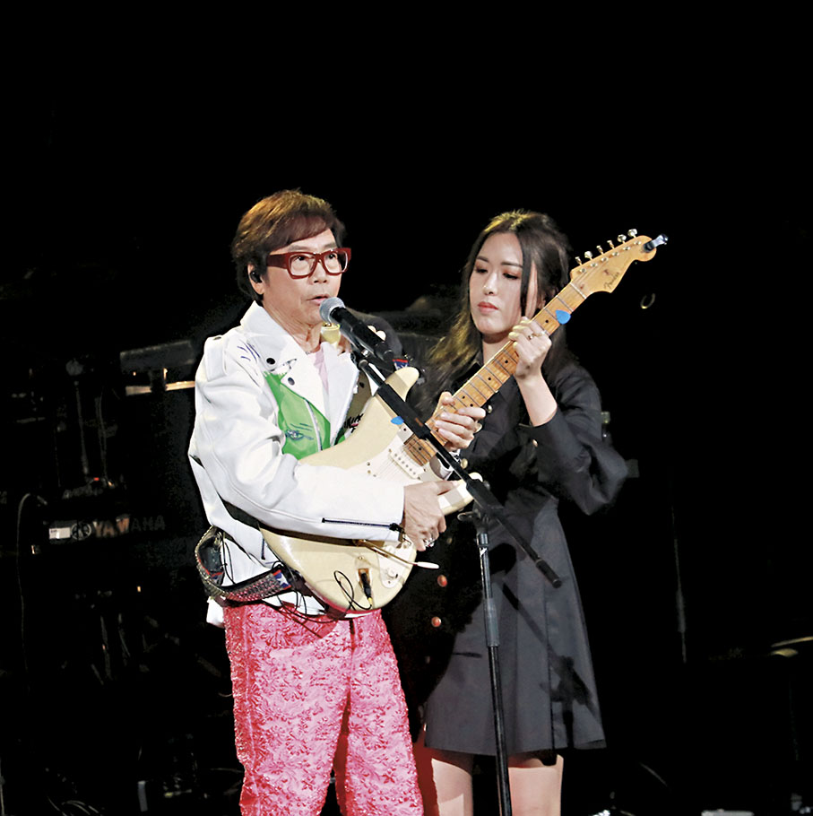 ◆ 彭健新有靚女幫拿結他，在萬人面前享艷福。