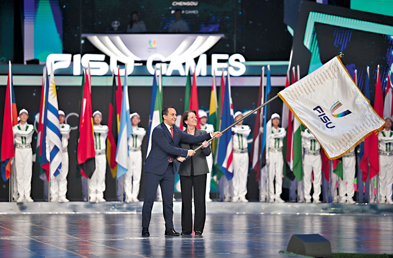 ◆ 下一屆大運會主辦城市代表、德國聯邦內政和國土部議會國務秘書馬哈茂德厄茲德米爾（左）和國際大體聯首席執委維麗娜伯克在會旗交接儀式上。  新華社