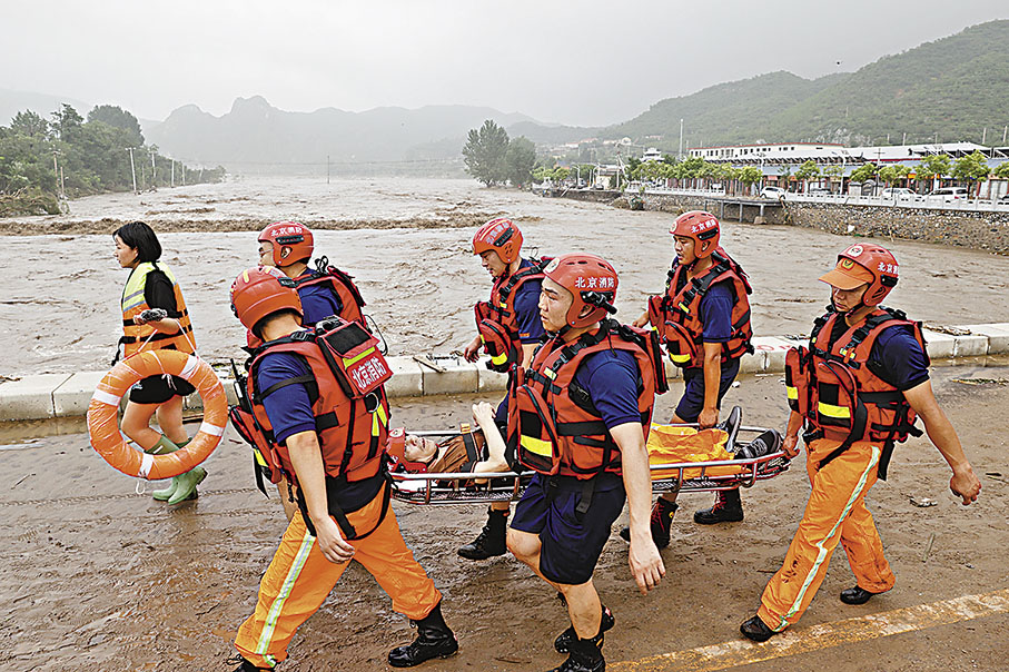 ◆8月1日，北京門頭溝區妙峰山鎮水峪嘴村，消防隊員轉移行動不便的老人出村。 中通社