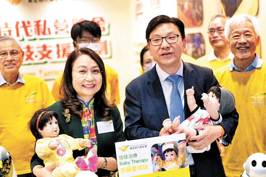 ◆孫玉菡（右）抱起娃娃機械人「金叵羅」。香港文匯報記者涂穴 攝