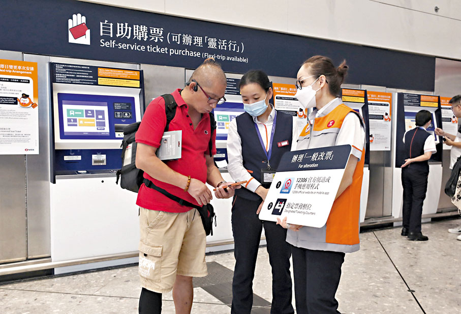 ◆西九高鐵站職員協助乘客改票。 香港文匯報記者郭木又  攝