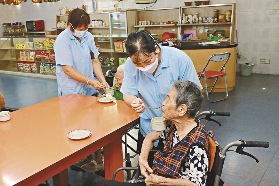 ◆ 工作人員餵長者吃飯。