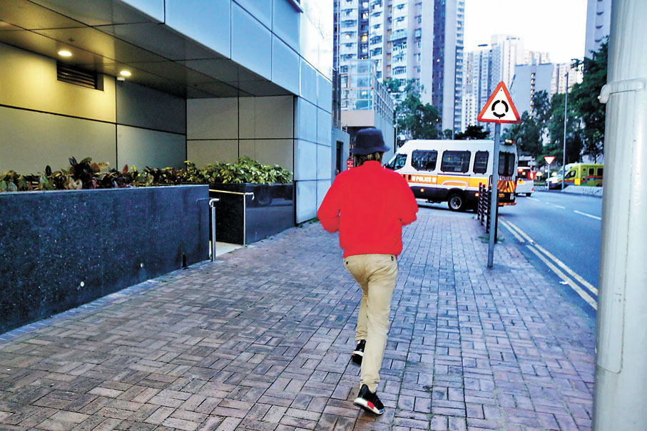 ◆郭鳳儀二哥（紅衫）獲准離開警署時急逃避記者。香港文匯報 記者鄺福強  攝