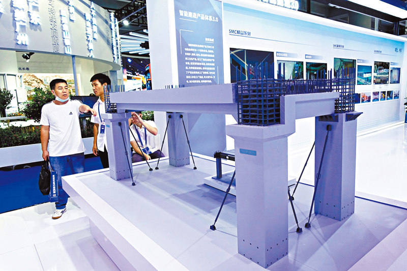 ◆ 觀眾在博覽會現場參觀智能生產線生產出來的混凝土建築組件。香港文匯報記者盧靜怡  攝