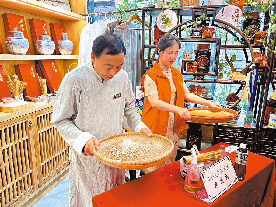 ◆港生王子月（右）學習製作水泛丸。香港文匯報記者王莉 攝