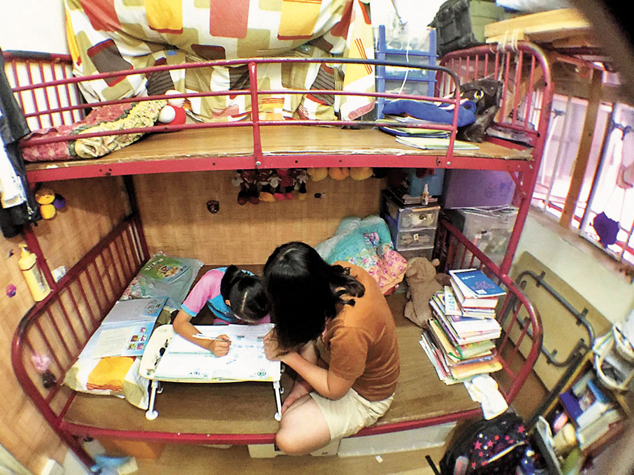 ◆有專家指，若兒童長期處於劏房等不理想環境，有機會造成智力發展遲滯。圖為學童在劏房內做功課。 資料圖片