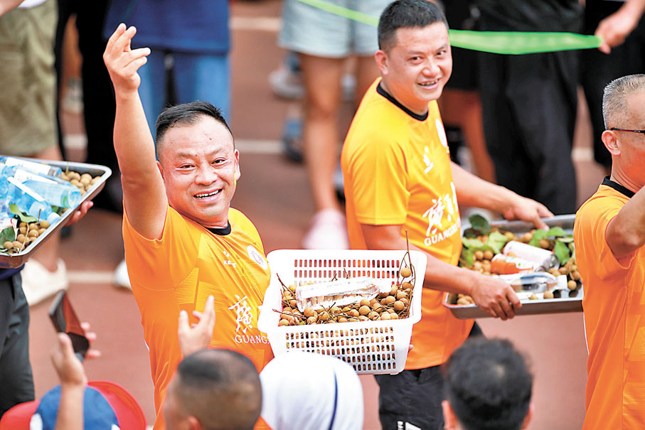 ◆廣西大學甘蔗汁隊球員在入場時展示當地美食。