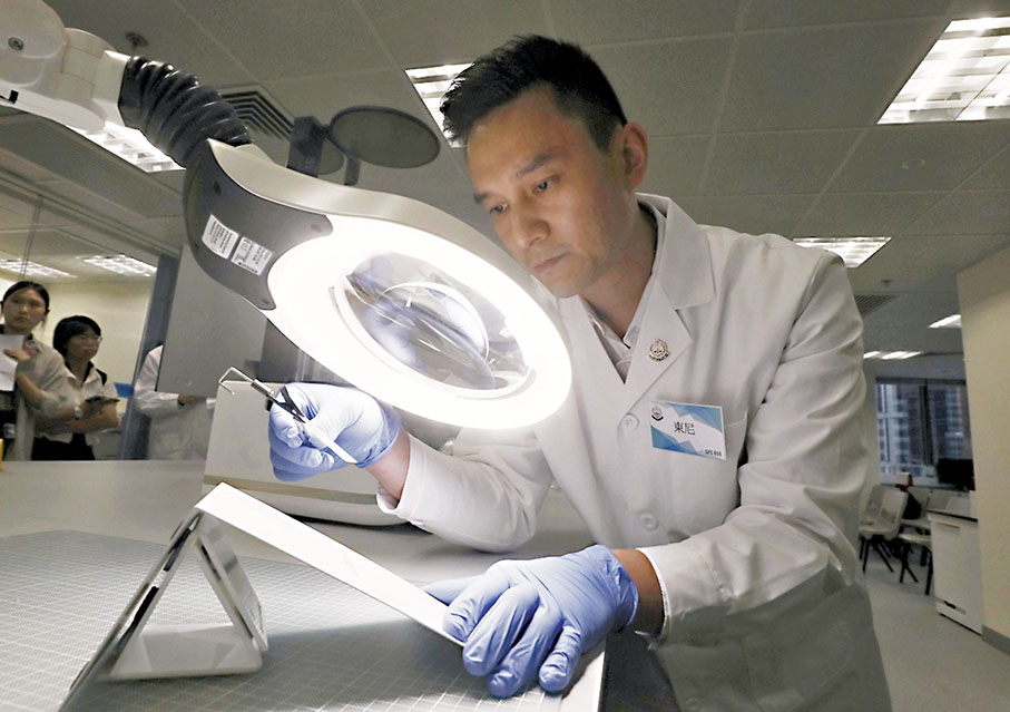 ◆鑑證科人員即場示範使用新技術對被火燒過的金屬材質提取指紋。 香港文匯報記者郭木又 攝