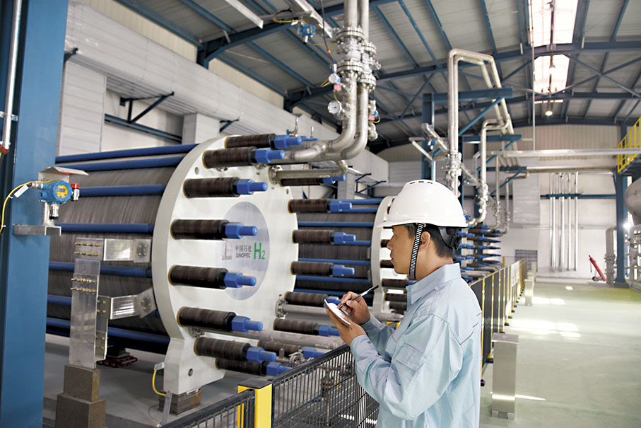 ◆中國石化新疆庫車綠氫示範項目的員工對製氫設備進行巡檢。 資料圖片