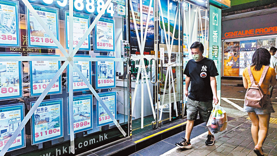 ◆超強颱風「蘇拉」襲港，天文台預告今晨懸掛八號烈風或暴風信號，並有機會改發十號風球。圖為商舖玻璃門窗貼上膠帶防風。香港文匯報記者萬霜靈  攝