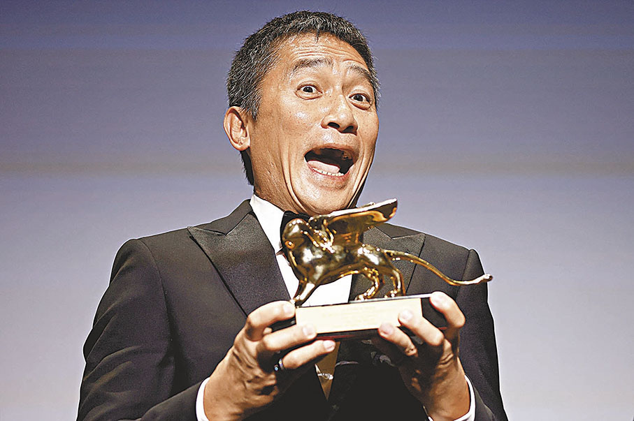 ◆ 梁朝偉手捧終身成就金獅獎，擺出鬼馬表情。 路透社