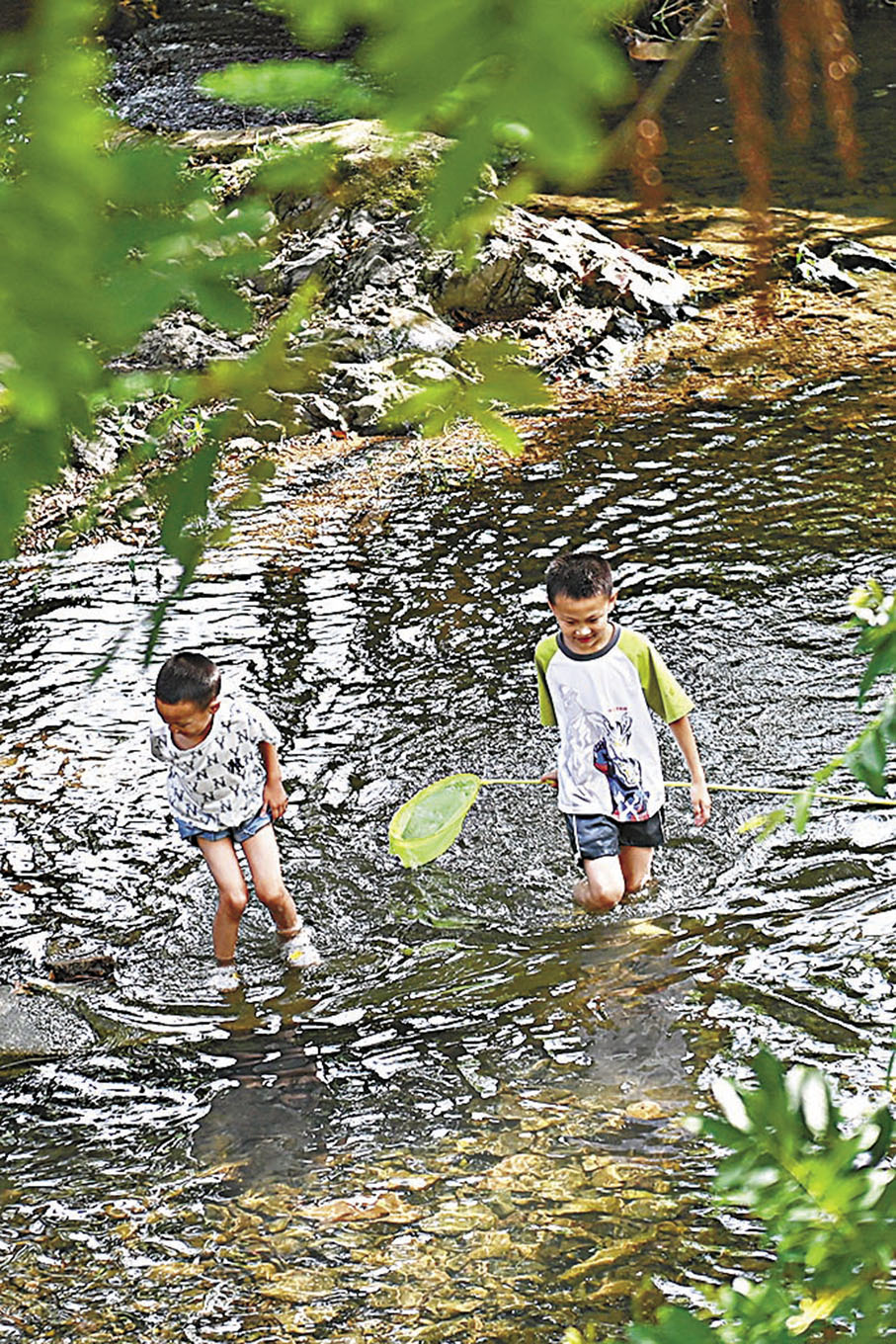 ◆小朋友在余姚市四明山鎮大村的溪水中遊玩。