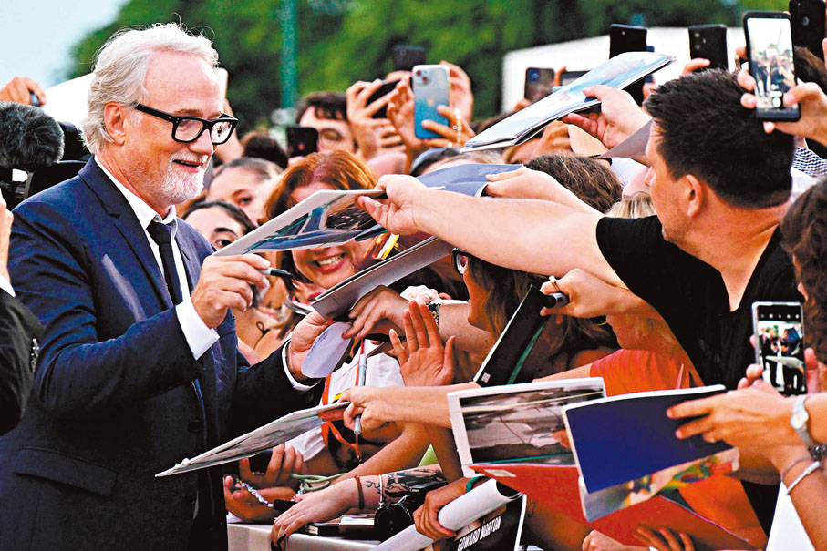 ◆大衛芬查為手持其作品的熱情影迷簽名留念。法新社