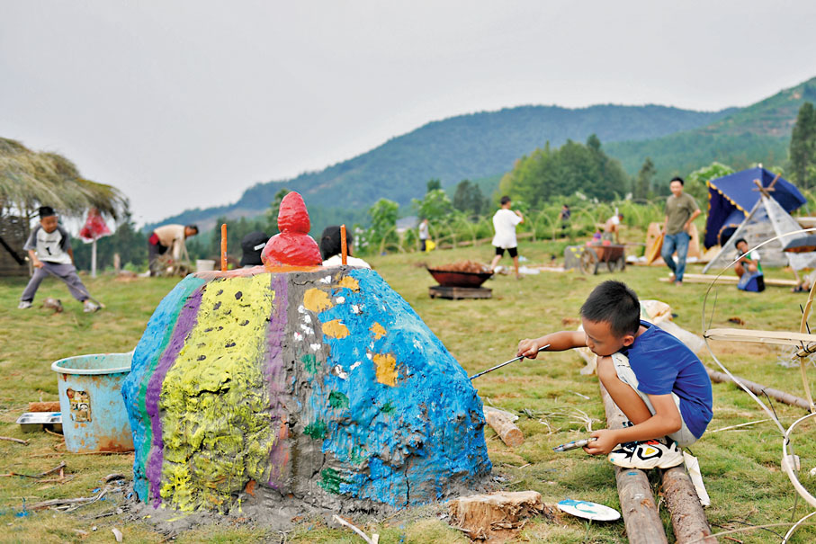 ◆小朋友在大元社草坪劇場的陶土裝置上繪畫。
