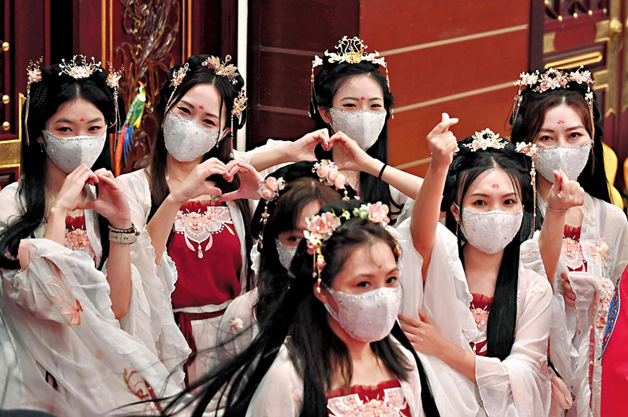 ◆七夕節已成為國家非物質文化遺產，又稱為「東方情人節」。圖為眾多「織女」於七夕時擺出心形手勢。 資料圖片