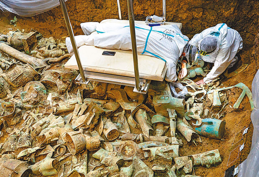 ◆在位於四川廣漢的三星堆遺址8號「祭祀坑」，發掘負責人、北京大學考古文博學院副教授趙昊（左）與考古工作者任俊鋒一起清理銅神壇。 新華社