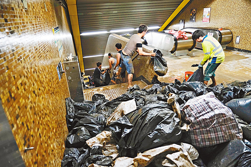 ◆9月8日，在黃大仙港鐵站內，工作人員接力將污泥從站內運出。 新華社