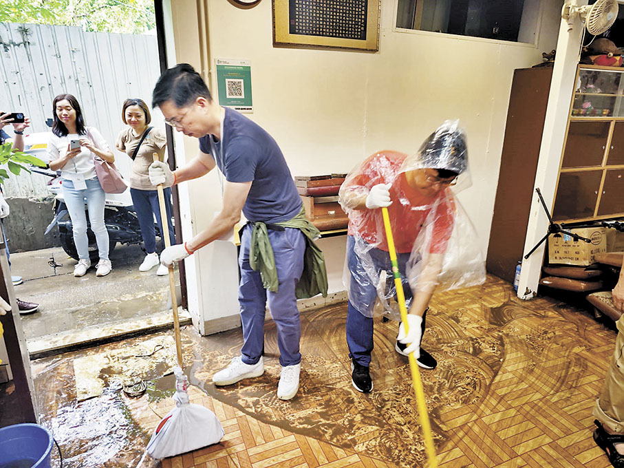 ◆ 胡鉅華與莫健榮幫牛池灣村一家受水浸影響的佛堂清理淤泥。