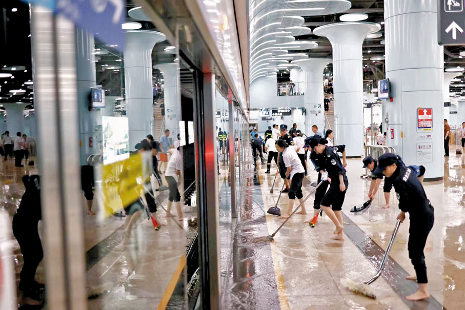 ◆深圳地鐵工作人員正在清理水漬，保障停運站點恢復運營。 香港文匯報深圳傳真