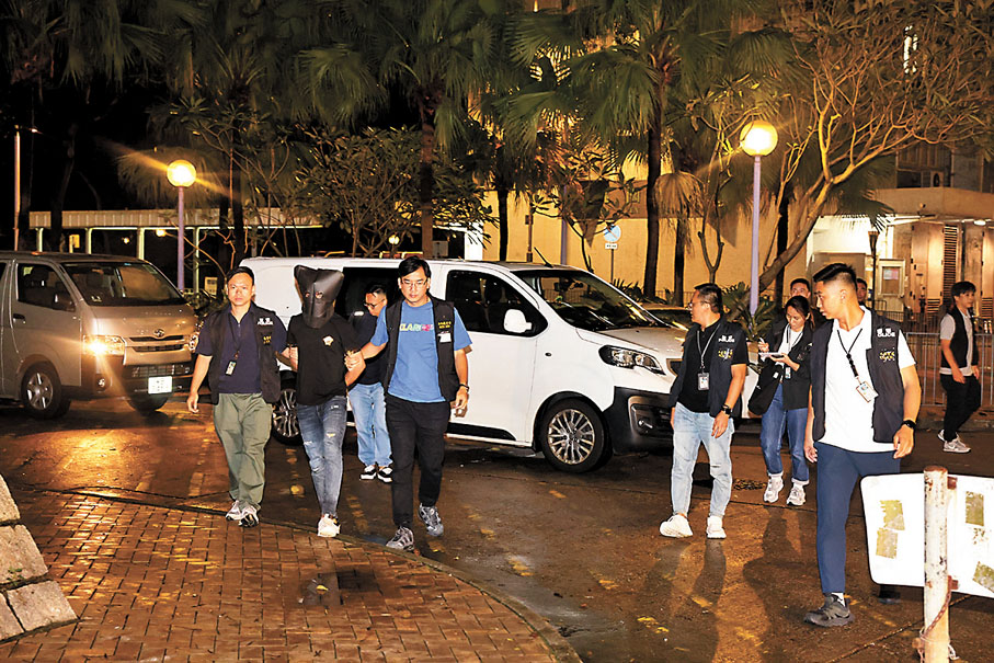 ◆重案組探員昨晚將錶行劫案被捕疑犯押返其竹園北邨寓所搜查。 香港文匯報記者鄺福強  攝