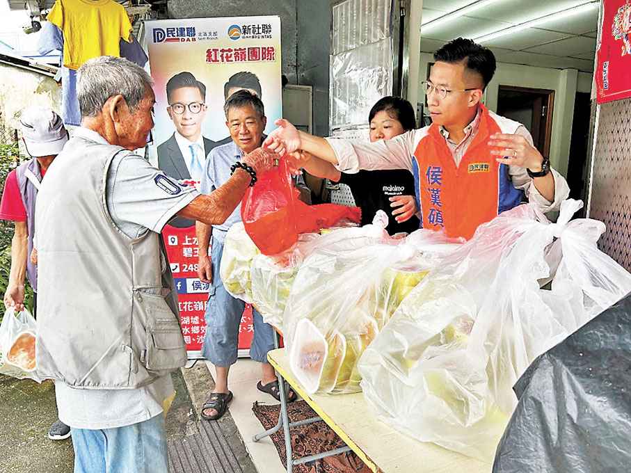 ◆侯漢碩和營盤村村代表林志強在派發愛心飯盒。
