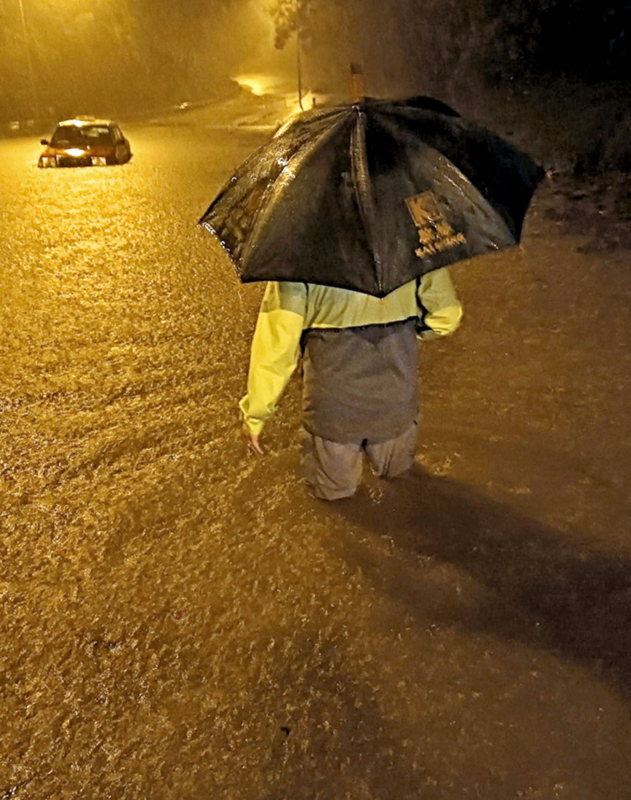 ◆陳繼偉在黑雨中趕赴澳景路山腳低窪位置救援車輛。