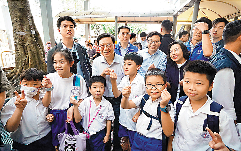 ◆ 李家超與偶遇的一群小學生合照。香港文匯報記者曾興偉  攝