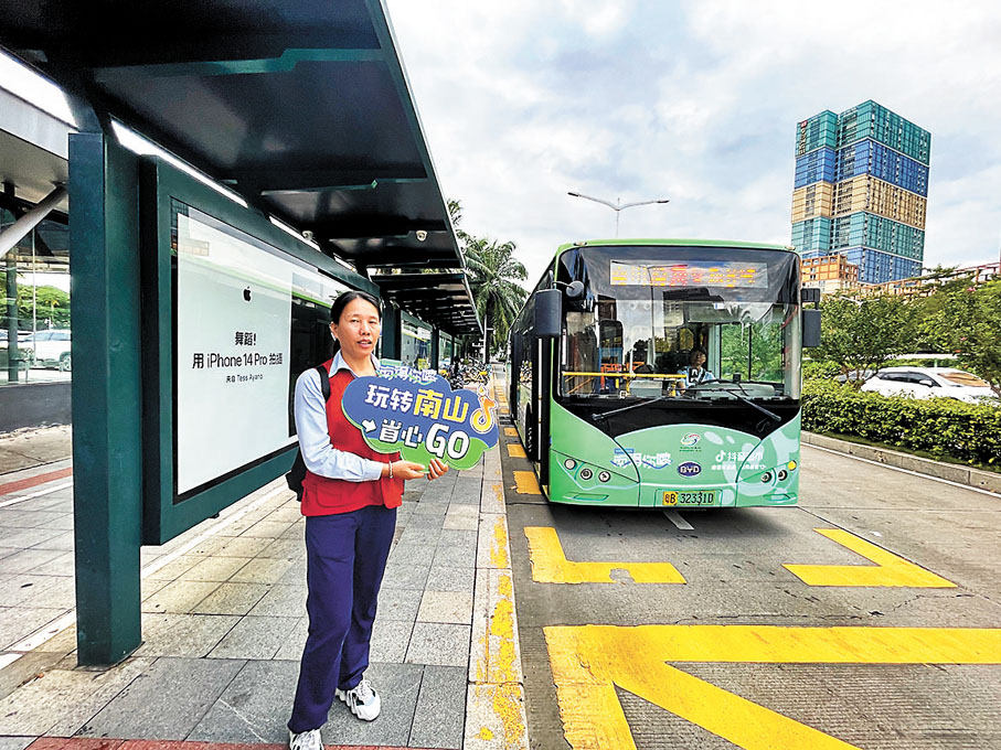 ◆工作人員正舉牌為港人指引線路。香港文匯報記者胡永愛  攝