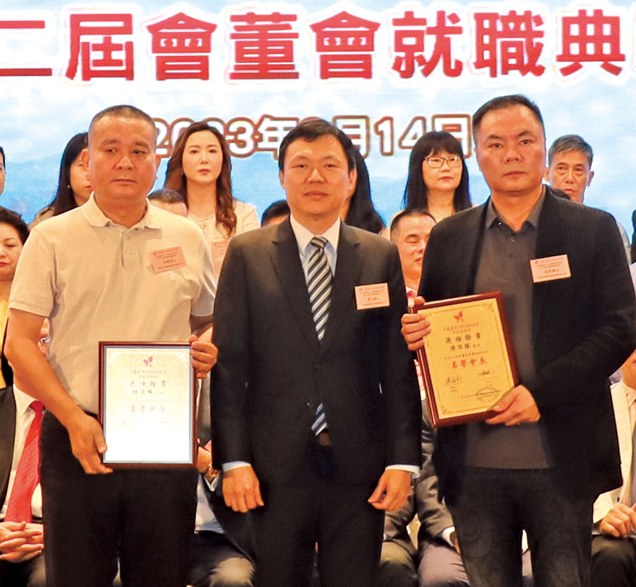 ◆黃小銳（中）頒發敦請書予平海同鄉會名譽會長代表陳偉勝及黃埠鹽洲同鄉會名譽會長代表林國強。