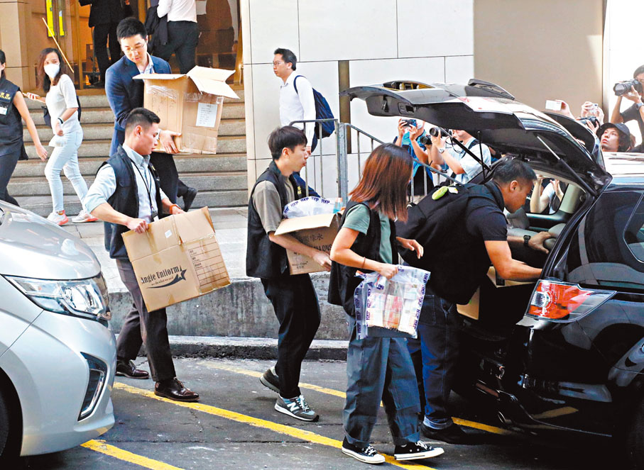 ◆商罪科警員在林作的中環找換店帶走多箱證物，包括大疊現金。 香港文匯報記者郭木又 攝
