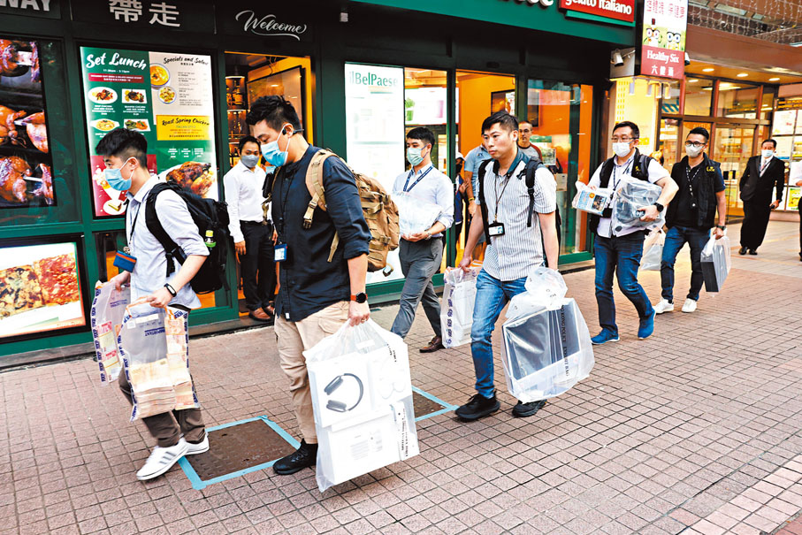 ◆商罪科探員在陳大怡找換店內帶走一批證物，包括大疊現金。 香港文匯報記者鄺福強 攝