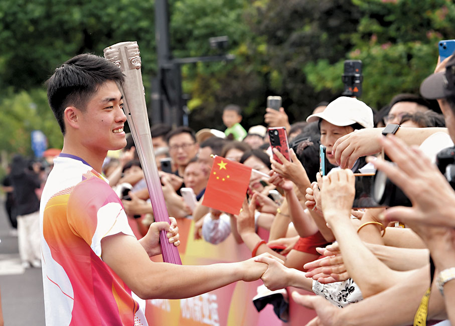 ◆吳易昺在火炬傳遞前與觀眾互動。 新華社