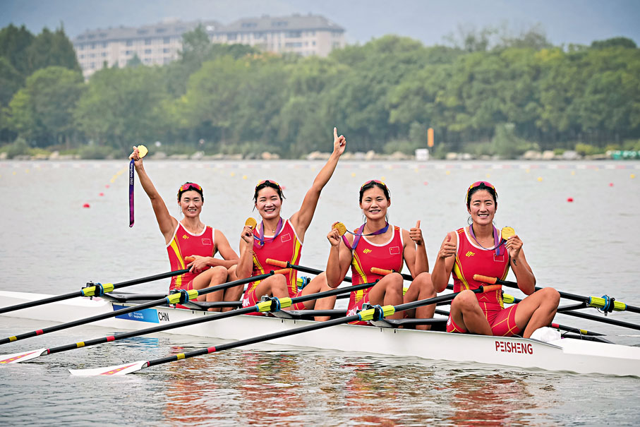 ◆陳雲霞、張靈、呂揚、崔曉桐（從左到右）手舉金牌在賽艇上慶祝。 新華社