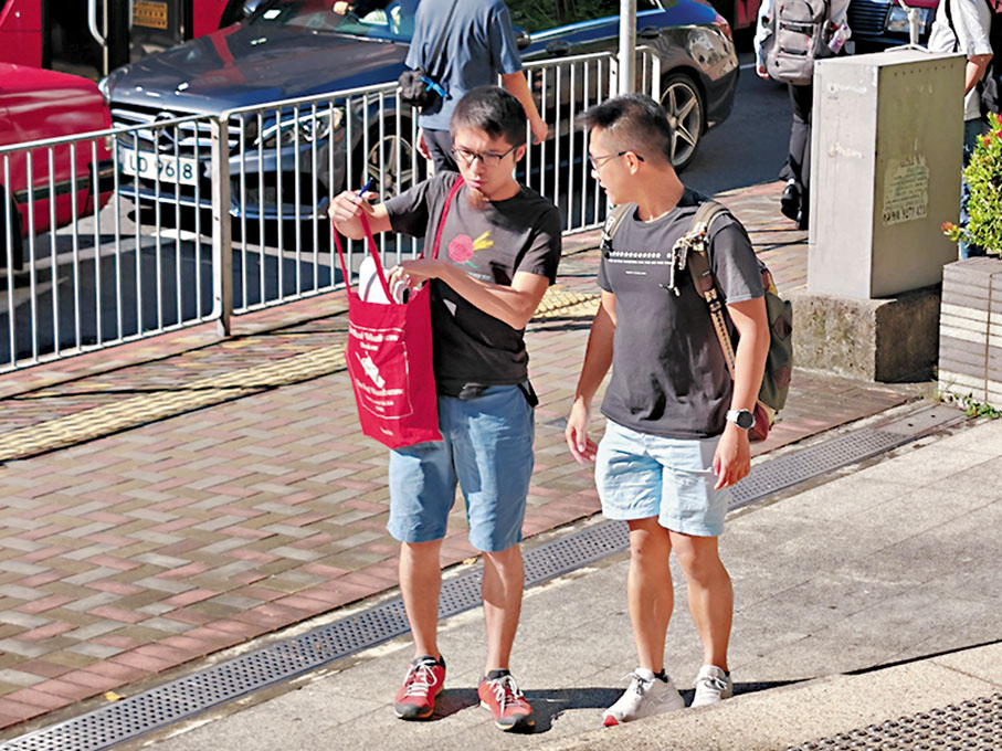 ◆昨日上午周嘉發（左）在黃浩銘（右）陪同下到九龍城裁判法院應訊。  香港文匯報記者張得民 攝