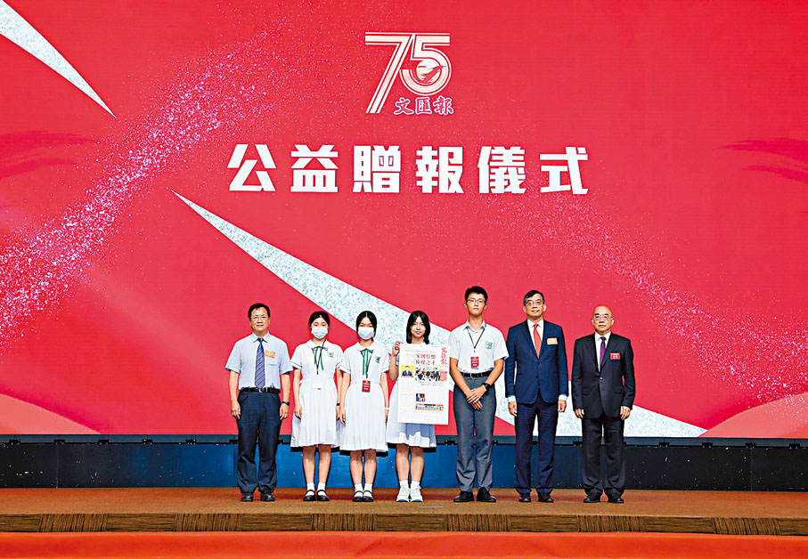 ◆慶典中舉行了公益贈報儀式，鄧健榮（右二）在吳明（右一）的陪同下贈送報章予培僑中學，4名學生代表接收。香港文匯報記者北山彥 攝