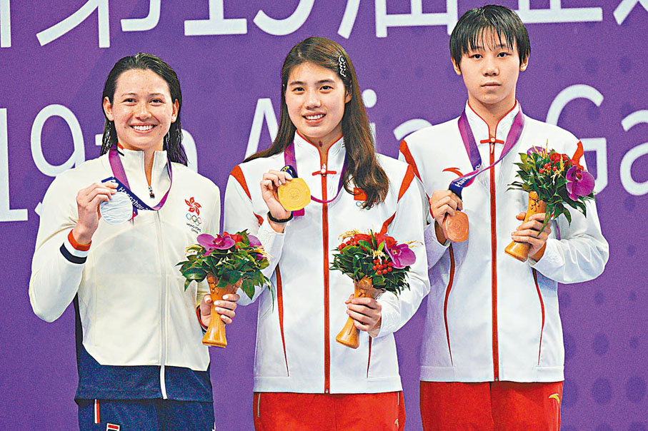 ◆何詩蓓（左起）與國家隊名將張雨霏、程玉潔並肩登上頒獎台。香港文匯報記者麥鈞傑  攝