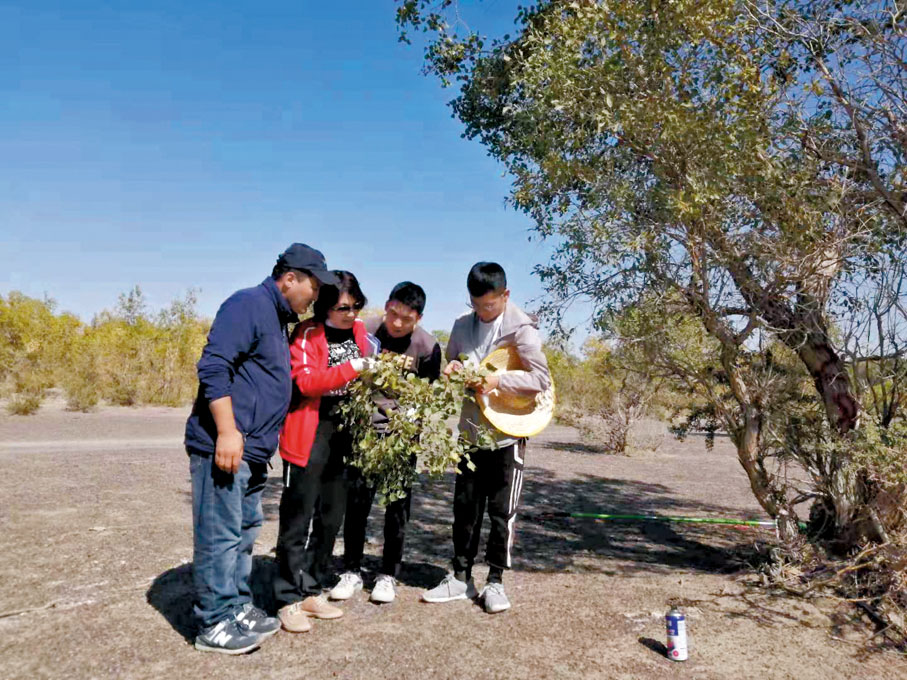 ◆2019年8月，李志軍（左二）在北疆托里縣胡楊林與管護人員交流。