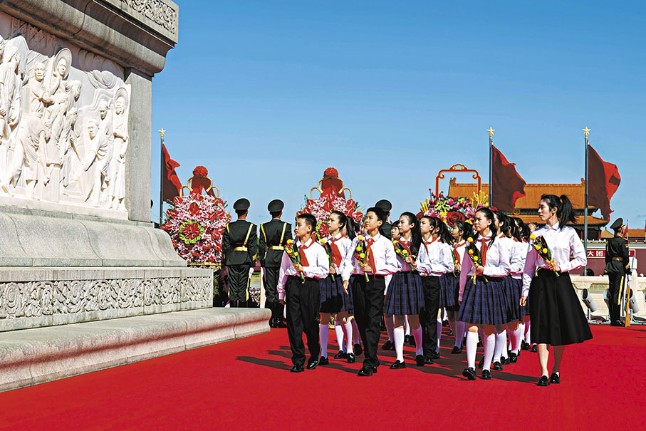 ◆少年兒童獻上手中鮮花並瞻仰紀念碑。 新華社