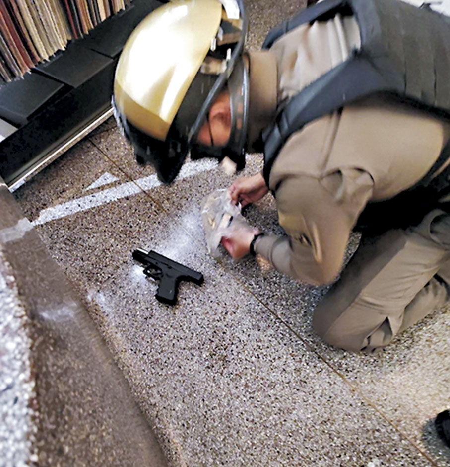 ◆警員在商場內檢起槍支。 路透社