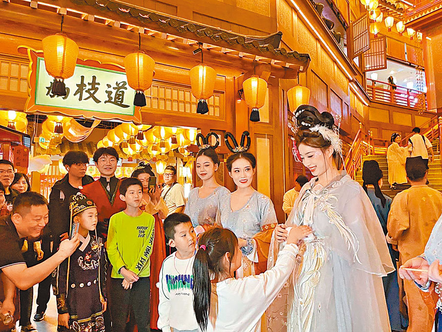 ◆遊客一連多日流連於長安十二時辰、大唐芙蓉園、大唐不夜城，全身心享受起唐「潮」人的慢生活。圖為遊客與長安麗人互動。香港文匯報陝西傳真