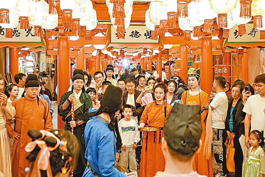 ◆遊客在長安十二時辰街市上與人互動。  香港文匯報陝西傳真