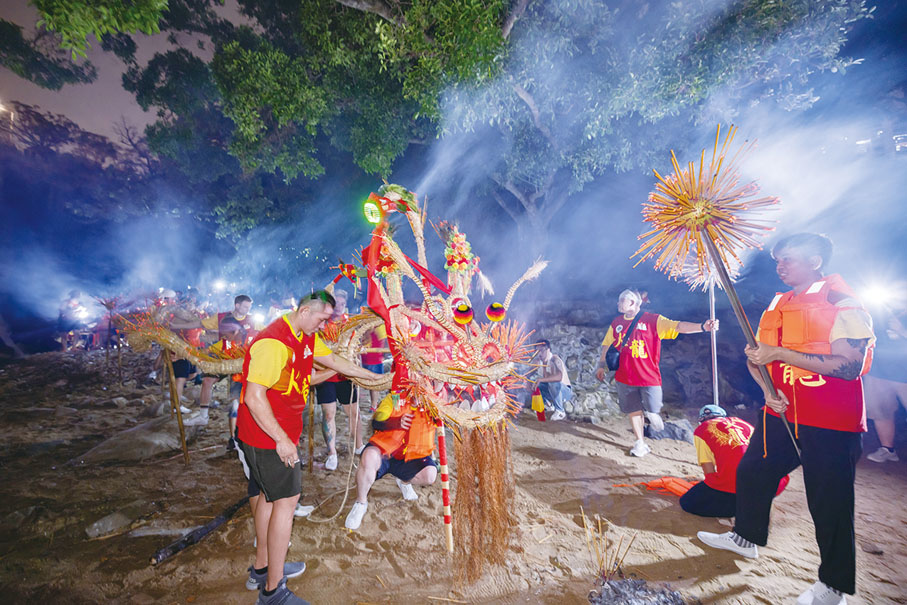 ◆ 巡遊後，眾健兒舞着火龍經華富邨至瀑布灣公園進行「龍歸滄海」儀式。