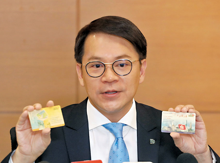 ◆陳克勤展示1998年立法會選舉及區議會選舉的紀念卡。  香港文匯報記者郭又木  攝