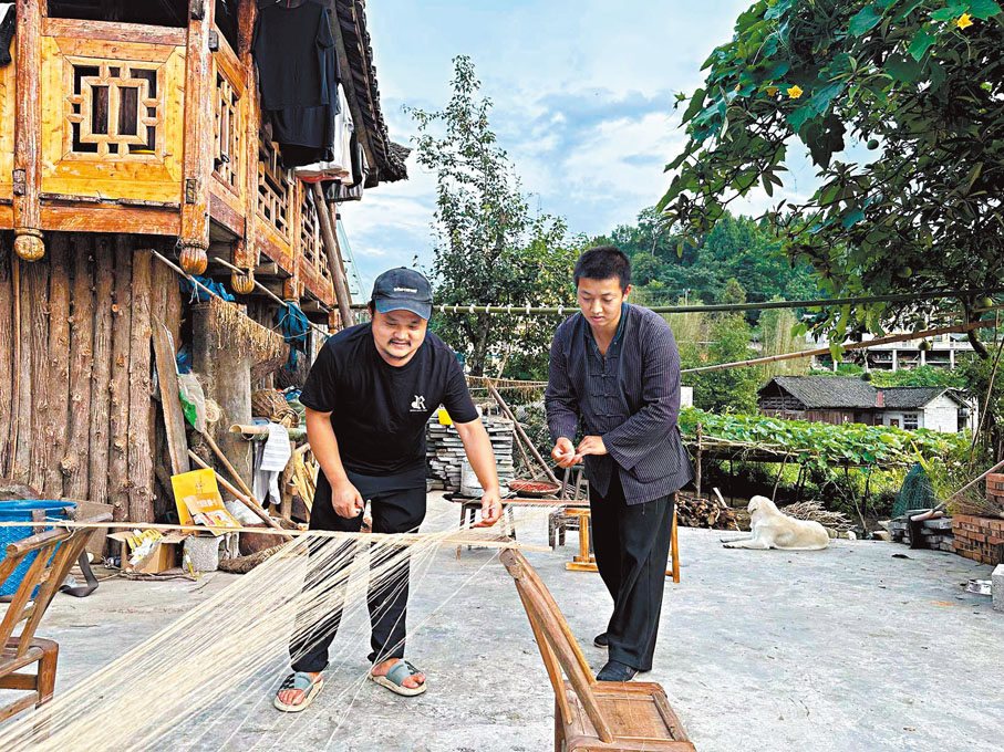 ◆向清標（左）和向宏俊在製作傳統紡織品「夏布」。 香港文匯報湖南傳真