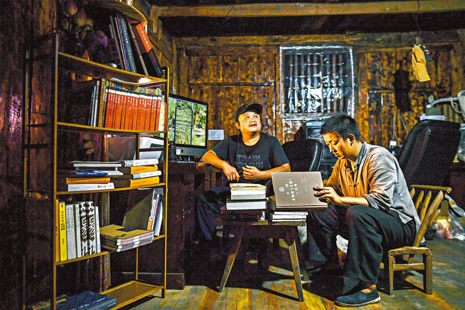 ◆向清標（左）的床頭擺着數十本工具書，他通過這些古籍學習古法製作技藝。香港文匯報湖南傳真