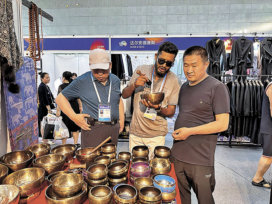 ◆普拉迪普·潘迪（中）在中國展會上向中國客人介紹尼泊爾特產商品。香港文匯報記者于海江  攝